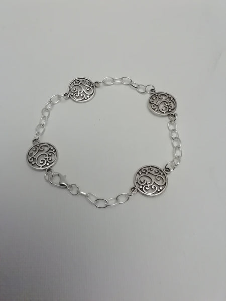 Bracelet avec 4 breloques argentées